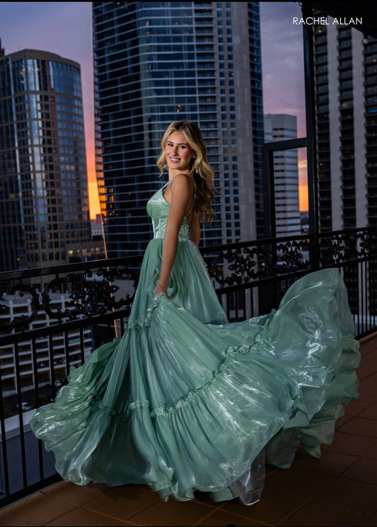 This shimmer tulle dress with its fun ruffle layered skirt is so elegant. Instock in sage size 20. Rachel Allan 70748